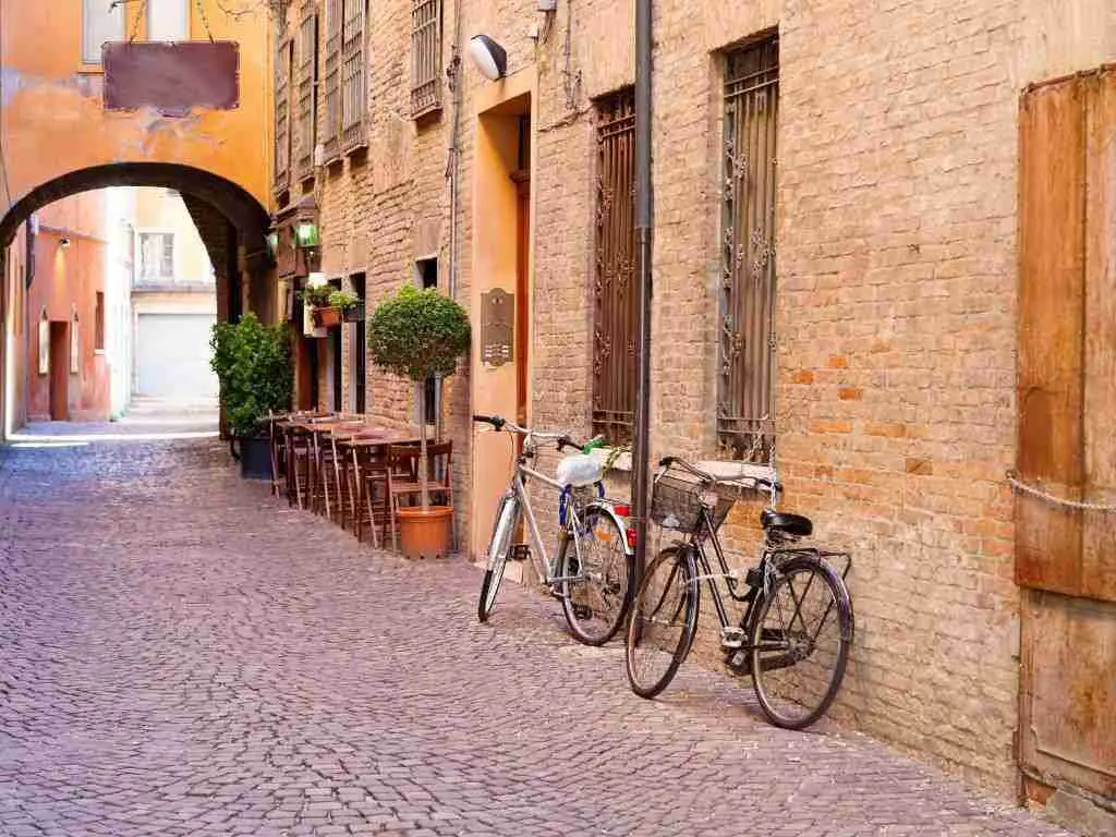 Bikes resting against the wall of a medieval street in Ferrara, Emilia-Romagna